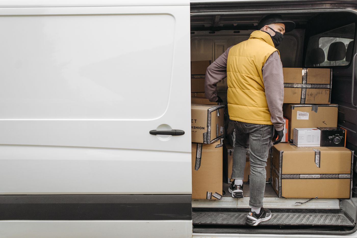 Delivery driver unloading packages from a van